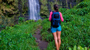 Woman standing on hiking trail to waterfall
